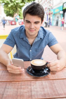 Genç adam, açık Cafe manifatura üstünde hareket eden telefon