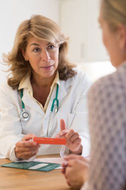 Erkek doktor ile hasta ilaç tartışıyor