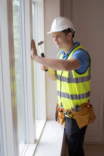 Trabalhador da construção civil instalando novas janelas na casa — Fotografia de Stock