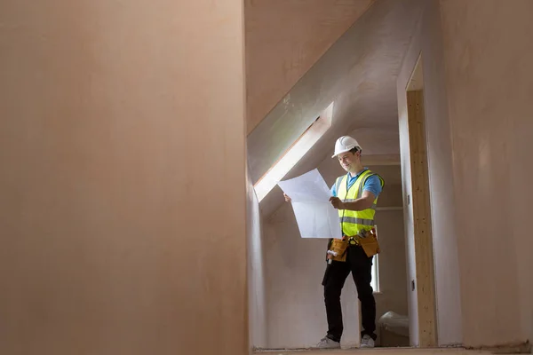 Architetto sul cantiere guardando piani di casa — Foto Stock