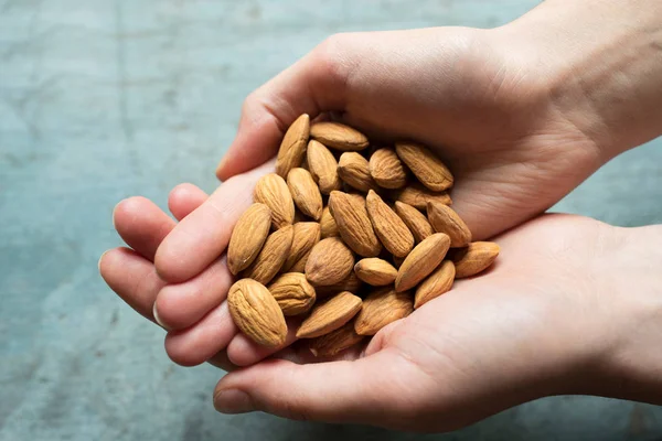 Primer plano de la mujer sosteniendo puñado de almendras — Foto de Stock