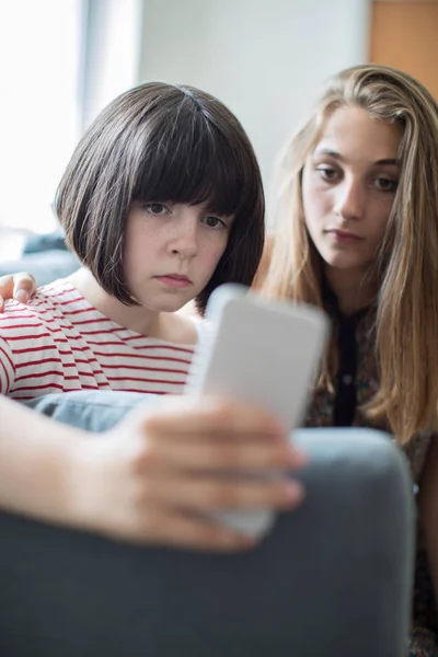 Tienermeisje met vriend gepest door tekstbericht — Stockfoto