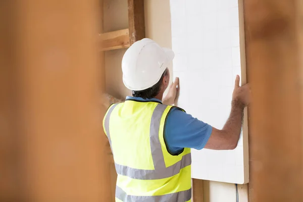 Construtor montagem placas de isolamento no telhado da nova casa — Fotografia de Stock