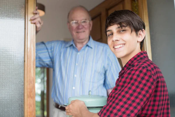 Teenage Boy Bringing Meal For Elderly Male Neighbour — Stock Photo, Image