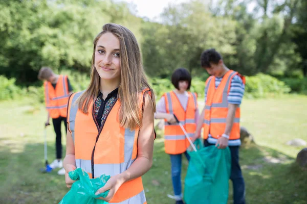 Groupe d'adolescents utiles ramassant la litière à la campagne — Photo