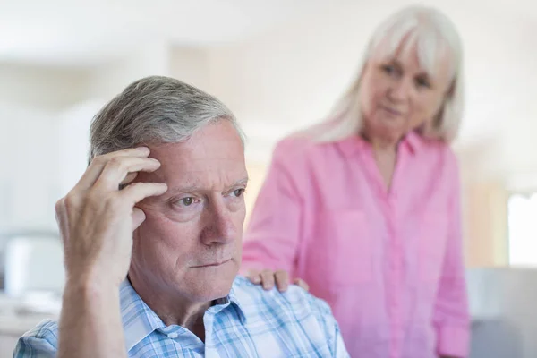 Зрелая женщина утешает мужчину депрессией дома — стоковое фото