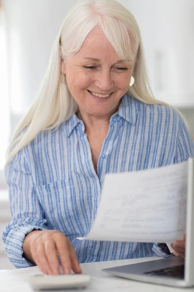 Улыбающаяся пожилая женщина рассматривает внутренние финансы — стоковое фото