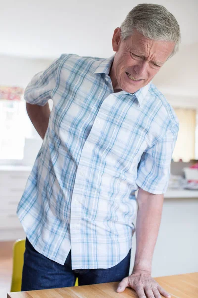 Oudere Man die lijden aan rugpijn, terwijl krijgen uit stoel A — Stockfoto