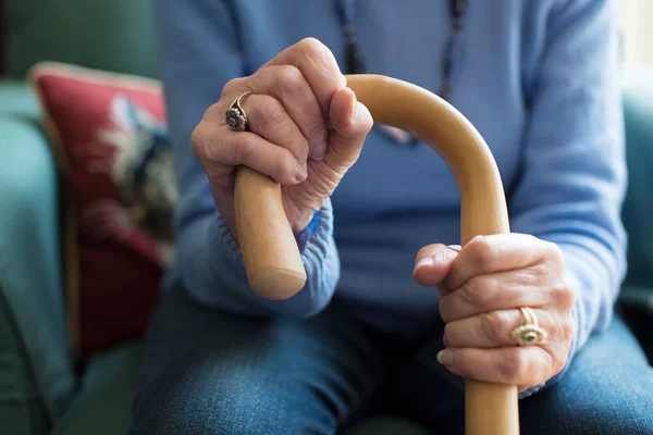 Close Up Of Senior Woman Sitting In Chair Holding Walking Cane — Stock Photo, Image