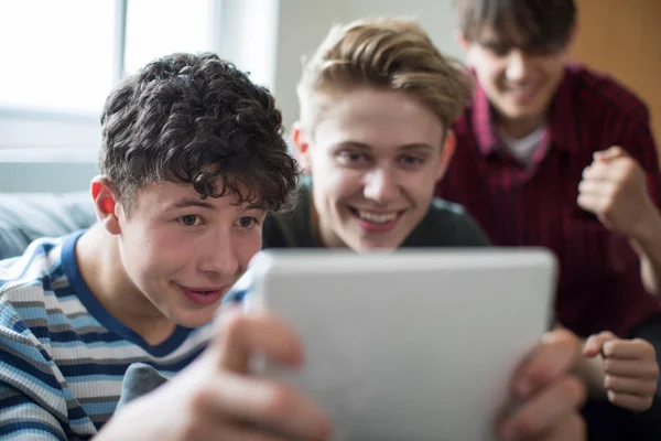 Trois adolescents garçons jouant jeu sur tablette numérique à la maison — Photo