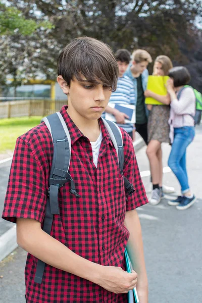 Menino infeliz sendo fofocado por amigos da escola — Fotografia de Stock