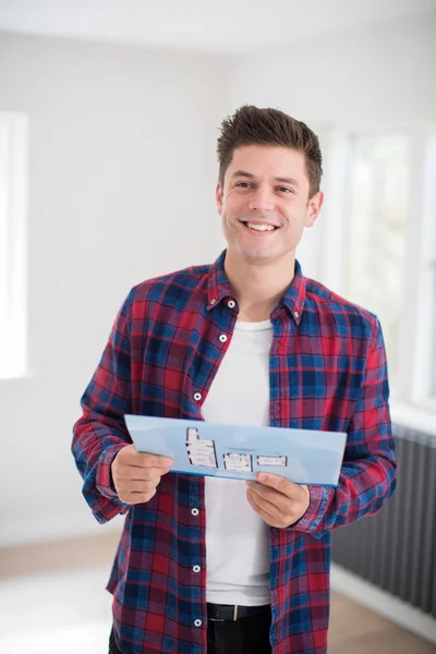 Hombre mirando folleto con detalles para un nuevo hogar —  Fotos de Stock