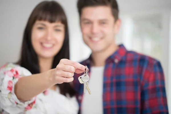 Retrato de jovem casal segurando chaves para a nova casa — Fotografia de Stock