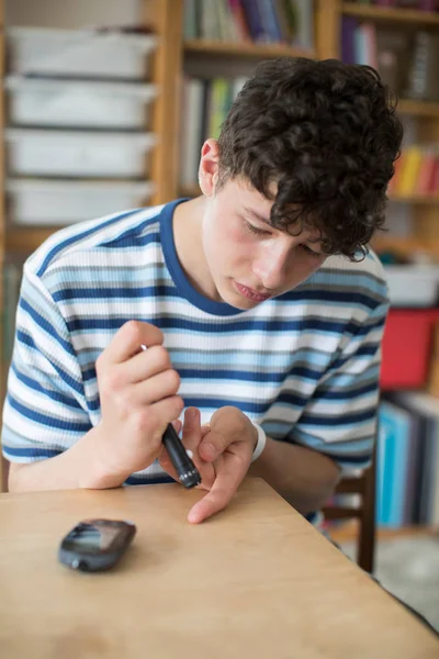 10 代の少年が自宅の血糖レベルをテスト — ストック写真