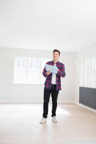 Homem que olha para o folheto com detalhes para a nova casa — Fotografia de Stock