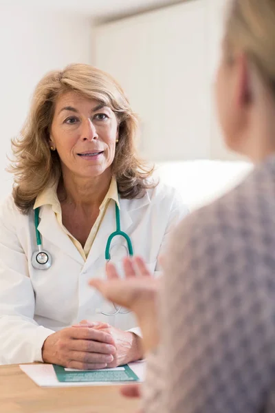 Médico discutiendo folleto con paciente femenina —  Fotos de Stock