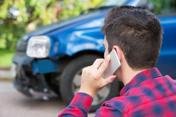 Hombre reportando accidente de coche en el teléfono móvil —  Fotos de Stock