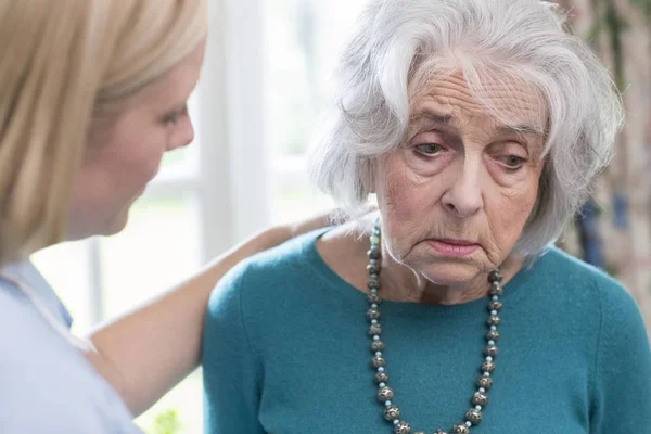 Assistente che parla con la donna anziana depressa a casa — Foto Stock