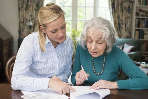 Frau hilft Seniorin bei Papierkram — Stockfoto