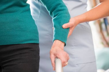 Çerçeve bakım işçisi ile Backgr içinde yürüyüş üst düzey kadının elleri arkasında