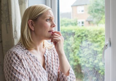 Sad Woman Suffering From Agoraphobia Looking Out Of Window clipart