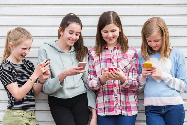 Gruppo di giovani ragazze all'aperto guardando i messaggi su cellulare Phon — Foto Stock