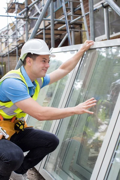 Trabalhador da construção civil se preparando para caber novas janelas — Fotografia de Stock