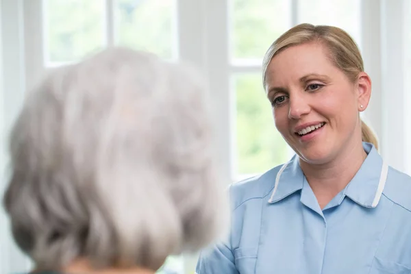 Vård arbetstagare talar till Senior Kvinna hemma — Stockfoto