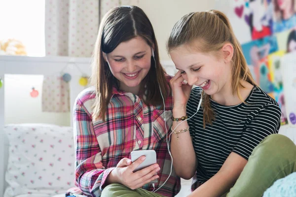 Két lány folyó zene-ból mozgatható telefon-ban hálószoba — Stock Fotó