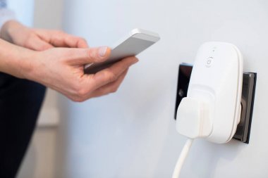 Akıllı Fişi Cep Telefonu Uygulamasını Kullanarak Kontrol Eden Kadın