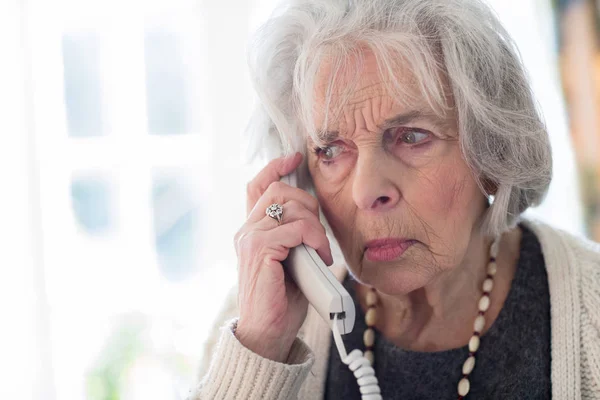 Mujer mayor preocupada contestando teléfono en casa —  Fotos de Stock