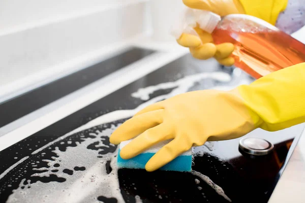 Close Up Of Woman Wearing Rubber Gloves Cleaning Kitchen Hob — Stock Photo, Image