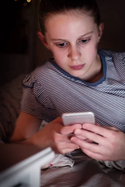 Jong meisje slachtoffer van pesten door tekstbericht liggend op Bed op Ni — Stockfoto