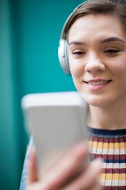 Kablosuz kulaklık için cep telefonundan müzik akışı kadın