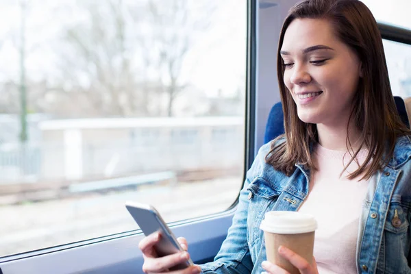 Tânără femeie mesaje text pe telefonul mobil în timpul călătoriei cu trenul — Fotografie, imagine de stoc