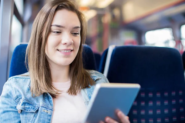 O tânără femeie care folosește tabletă digitală în timpul călătoriei cu trenul — Fotografie, imagine de stoc