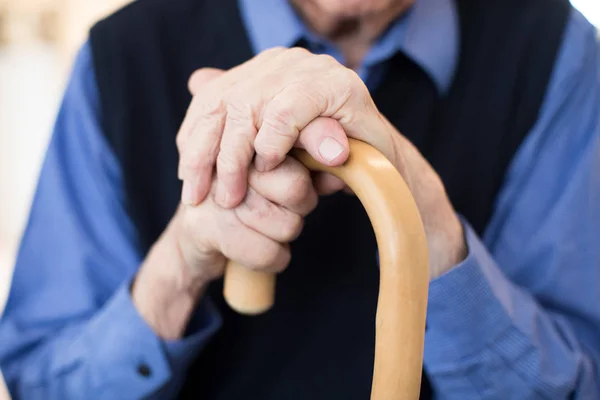 Закрыть пожилого человека, держащего трость — стоковое фото