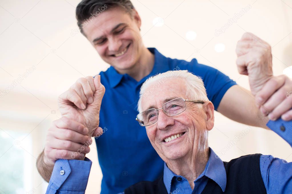 Male Nurse Assessing Senior Stroke Victim By Raising Arms