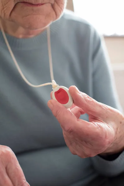 Zblízka nemocný Senior ženy držící osobní Alarm tlačítko na — Stock fotografie