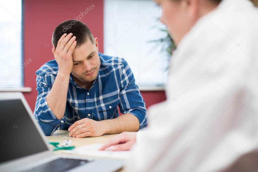 Worried Man Meeting With Female Doctor In Surgery