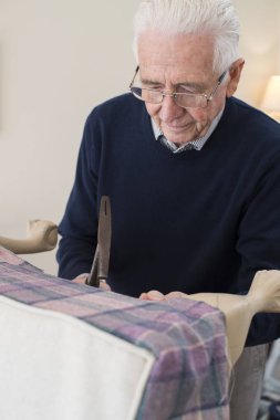 Senior Man Re-Upholstering Chair clipart