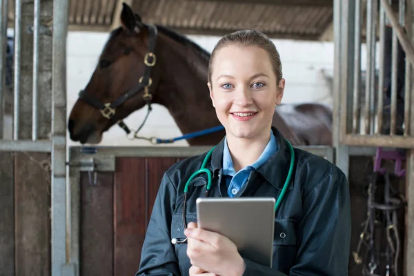 Retrato de veterinaria femenina con tableta digital examinando caballo en St. —  Fotos de Stock