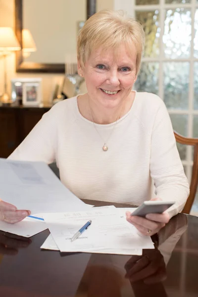 Glückliche Seniorin überprüft Haushaltsfinanzen zu Hause — Stockfoto