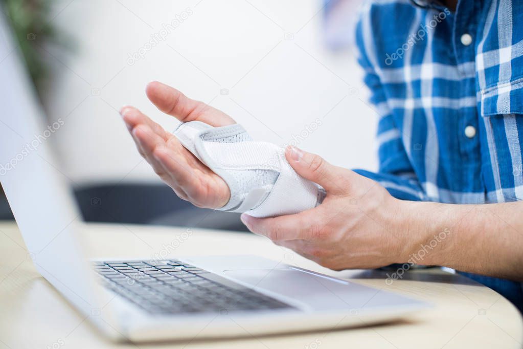 Close Up Of Businessman Using Laptop Suffering From Repetitive S