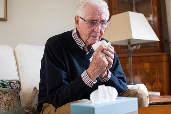 Uomo anziano a casa che soffre di raffreddore o influenza virus — Foto Stock