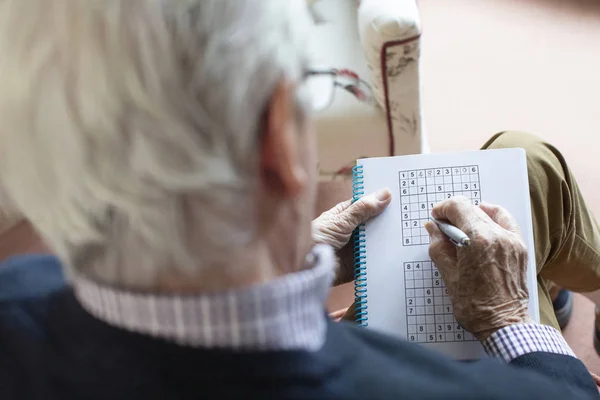 Evde Sudoku Bulmacası Yapan Kıdemli Adam — Stok fotoğraf