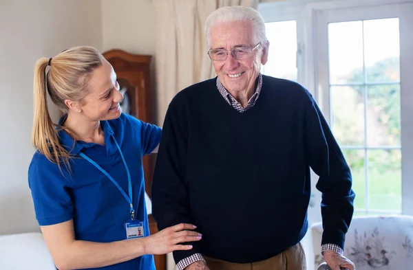 Senior Man Using Walking Frame Being Helped By Care Worker — Stock Photo, Image