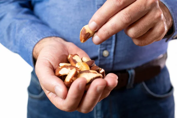 Close Up Studio Shot Of Mature Man Eating Brazil Nuts — Stock Photo, Image