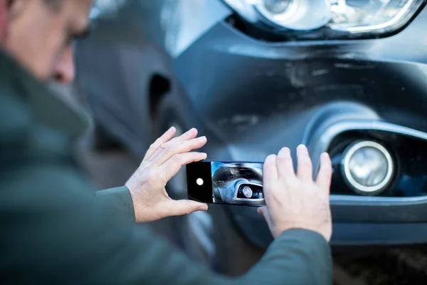 Motorista masculino tirando foto de carro danificado após acidente para seguro — Fotografia de Stock