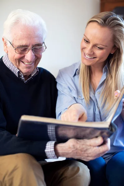 Grandfather Looking Photo Album Adult Granddaughter — Stock Photo, Image